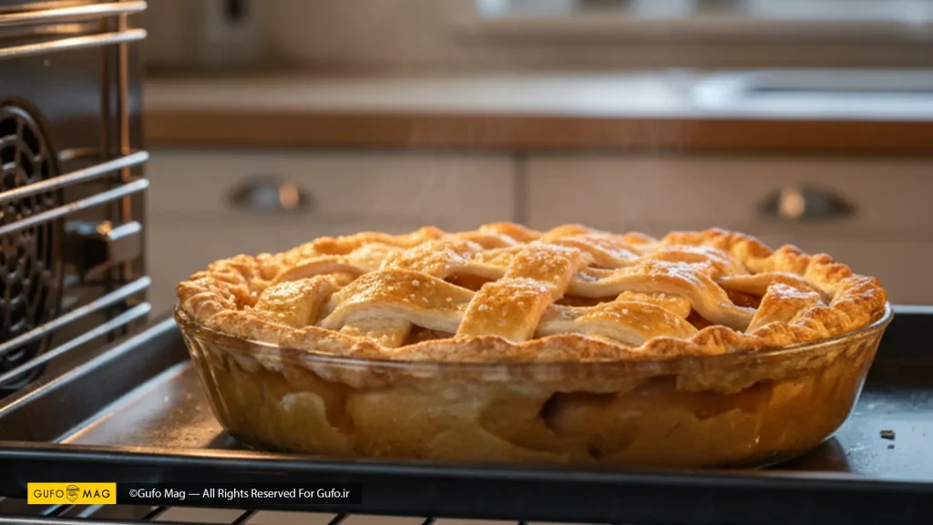 پای سیبی با رویه مشبک و طلایی که در حال پخت در داخل یک فر گرم