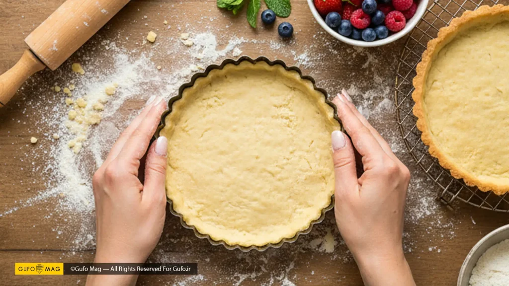 فرم دادن خمیر تارت در قالب، با مواد اولیه شیرینی‌پزی