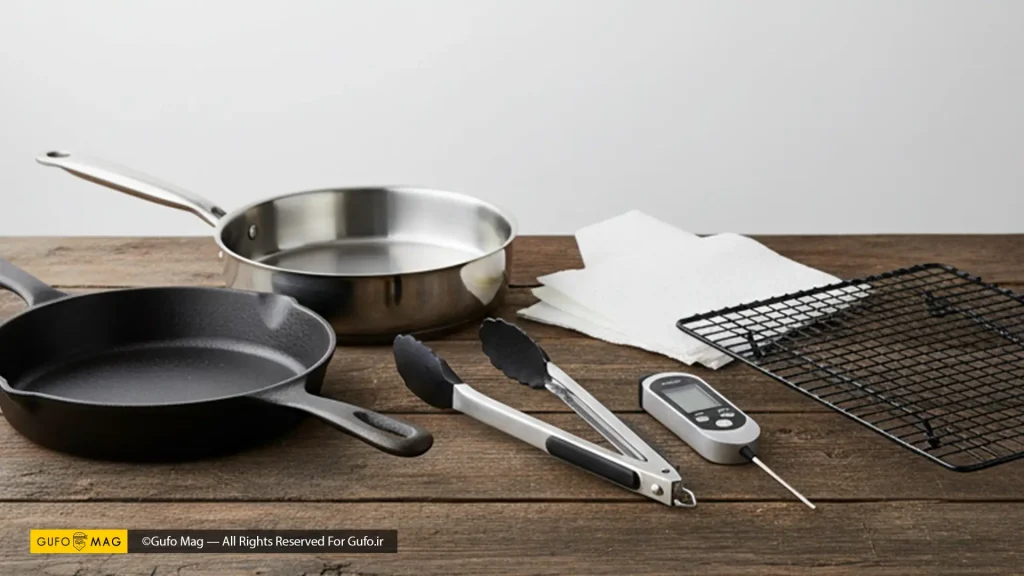 مجموعهای از ابزارهای آشپزخانه شامل تابهها، انبر، دماسنج