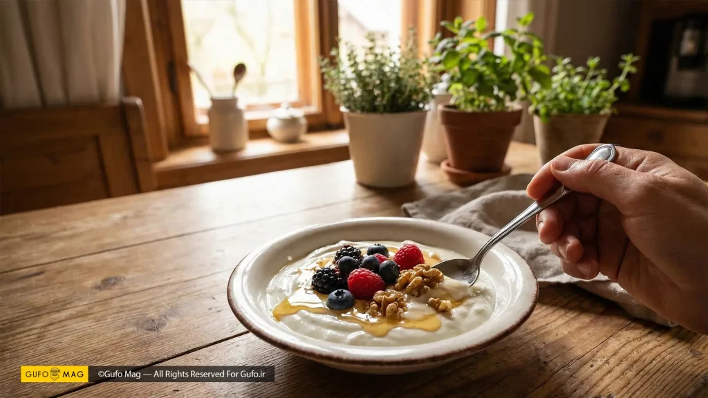 سرو و لذت بردن از یک کاسه ماست خانگی غلیظ تزیین شده با میوههای تازه و عسل