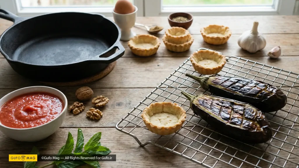 مواد اولیه تازه شامل بادمجان کبابی، سیر، گوجه و نان‌های تارت نمکی برای تهیه میرزاقاسمی